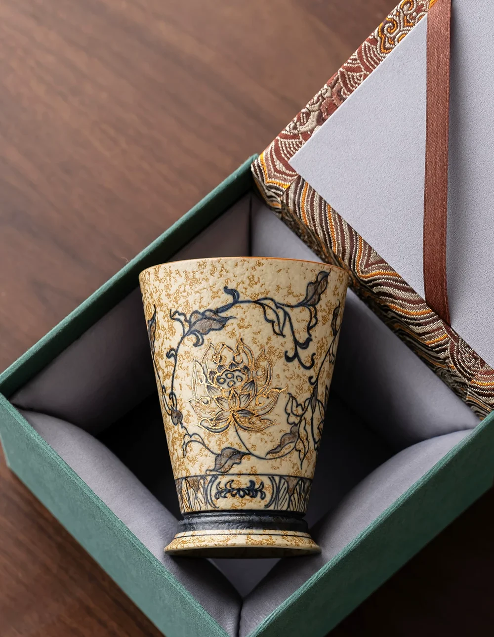 A Trailing Lotus porcelain cup presented in a patterned gift box